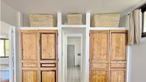 A hallway with wooden cabinets, baskets on top, and a view into another room. - Luxury villa - Les Galets (La Ciotat)