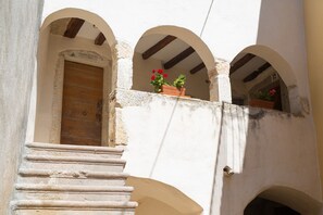 A building with a wooden door, a staircase, and arched windows. - Vacation home Domagoj with Jacuzzi (Vrbnik)