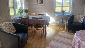 A cozy room with a dining table, chairs, a sofa, and a small side table. - 4 Person Holiday Home in Uddevalla (Uddevalla)