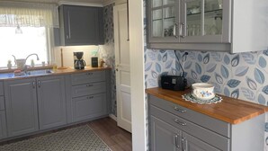 A kitchen with grey cabinets, a coffee maker, a radio, and a patterned backsplash. - 4 Person Holiday Home in Uddevalla (Uddevalla)