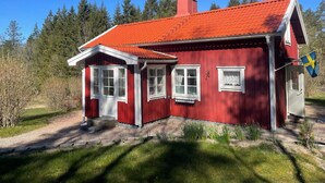 A red house with a red roof, white windows, and a Swedish flag. - 4 Person Holiday Home in Uddevalla (Uddevalla)