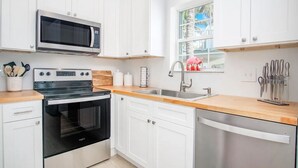 A modern kitchen with white cabinets, a microwave, a stove, a sink, and a dishwasher. - Open Ocean, Sunrise and Moonrise. Tropical fish and Seabirds at your fingertips! (Duck Key)