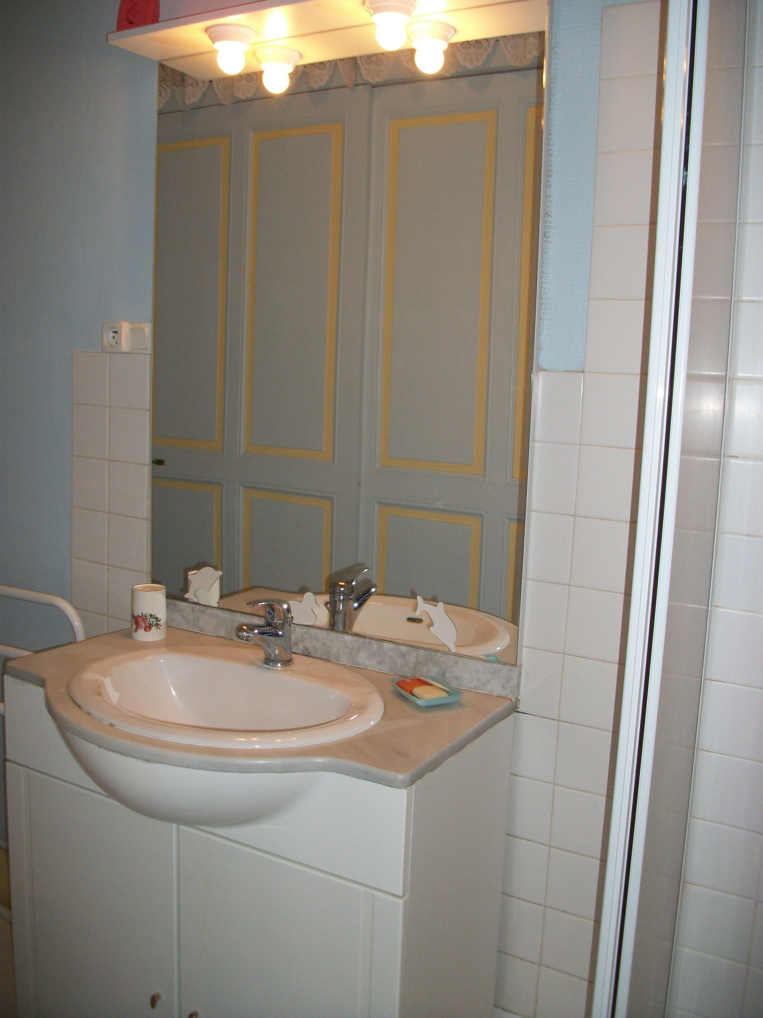 Ein Badezimmer mit Waschbecken, Spiegel und zwei Handtuchhaltern.