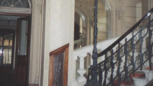 A grand staircase with ornate black railings and a decorative black chandelier. - Character apartment (Mont-Dore)
