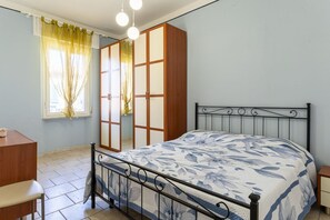 A bedroom with a bed, a wardrobe, a desk, and a window with curtains. - A bright apartment that sleeps up to four people, renovated with furnishings made by local artisans and located on the fourth floor (no elevator) in one of Livorno's most characteristic areas. The location is strategic: the sea and main attractions are w (Livorno)