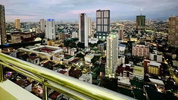 Vista panorámica de una ciudad, con diversos tipos de edificios y cielo despejado.
