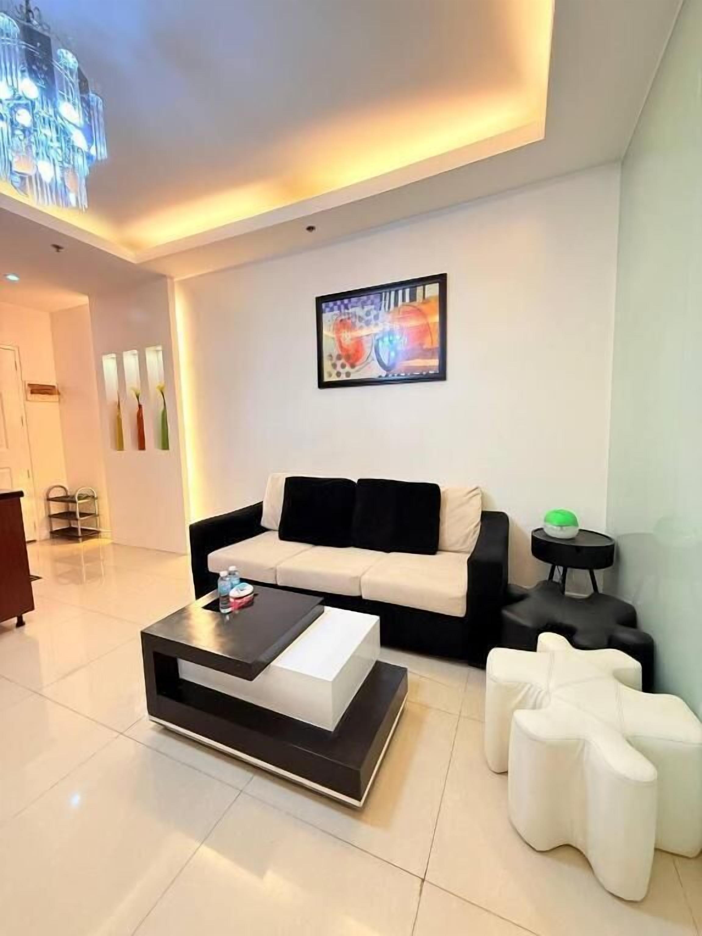 A modern living room with a sofa, a coffee table, and a unique white pouf.