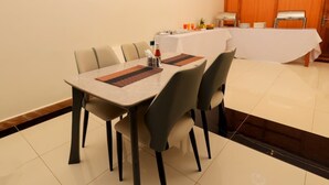 A dining area with a table, chairs, and a buffet setup. - Sea bridge view hotel mbarara (Mbarara)