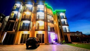 A multi-story residential building with balconies, a driveway, and a parked car. - Sea bridge view hotel mbarara (Mbarara)