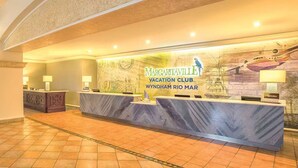 A reception area with a marble counter, a large mural, and a registration sign.