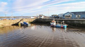 Un puerto con barcos amarrados, un muelle y un edificio con señalización.