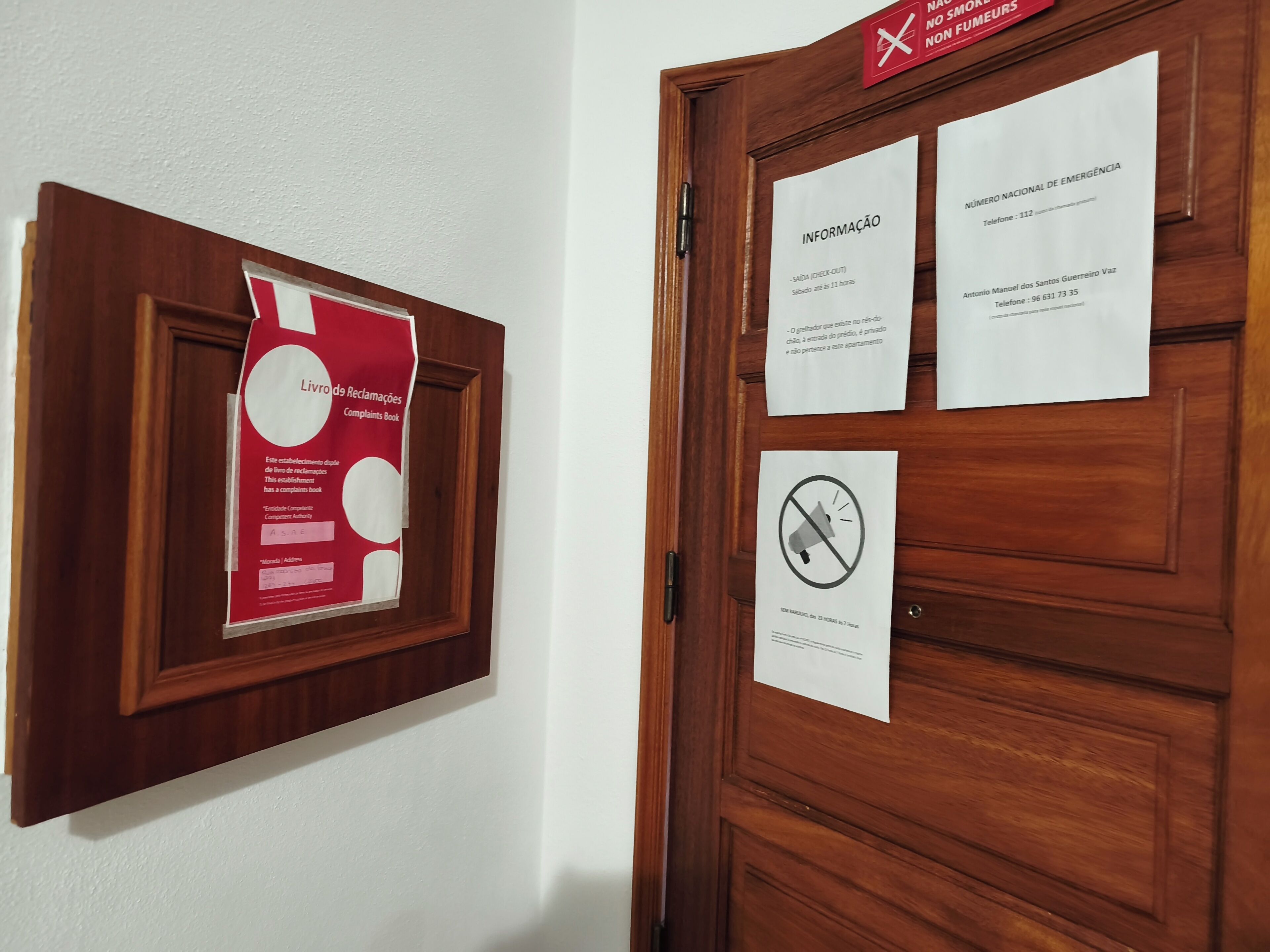Une porte sur laquelle est affiché un livre de réclamations, les coordonnées des personnes à contacter en cas d’urgence et un panneau indiquant qu’il est interdit d’utiliser un mégaphone.