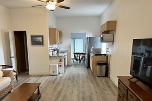 A compact living space with a kitchenette, a dining area, and a seating area.