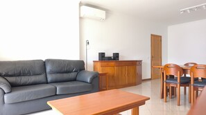 A living room with a sofa, a wooden table, a cabinet with speakers, and a door. - OLD TOWN, Apt. 110m2 on Avenida da Liberdade, AIR CONDITIONING/CAPBLE TV/FREE Wi-Fi (Albufeira)