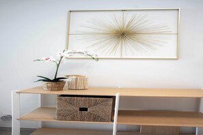 A framed artwork on a wall, a potted orchid, and a woven basket on a wooden shelf. - One Lux Stay 2BR/ 2BA Antwerp near Central Station (Antwerpen)