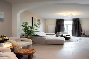 A modern living room with a sectional sofa, a round coffee table, and a potted plant. - One Lux Stay 2BR/ 2BA Antwerp near Central Station (Antwerpen)