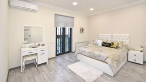 Un dormitorio con cama, cómoda, espejo y radiador.