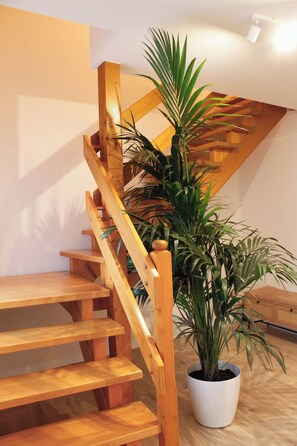 A wooden staircase with a potted plant beside it.