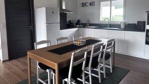 Una cocina moderna con armarios blancos, encimera negra y ventana.