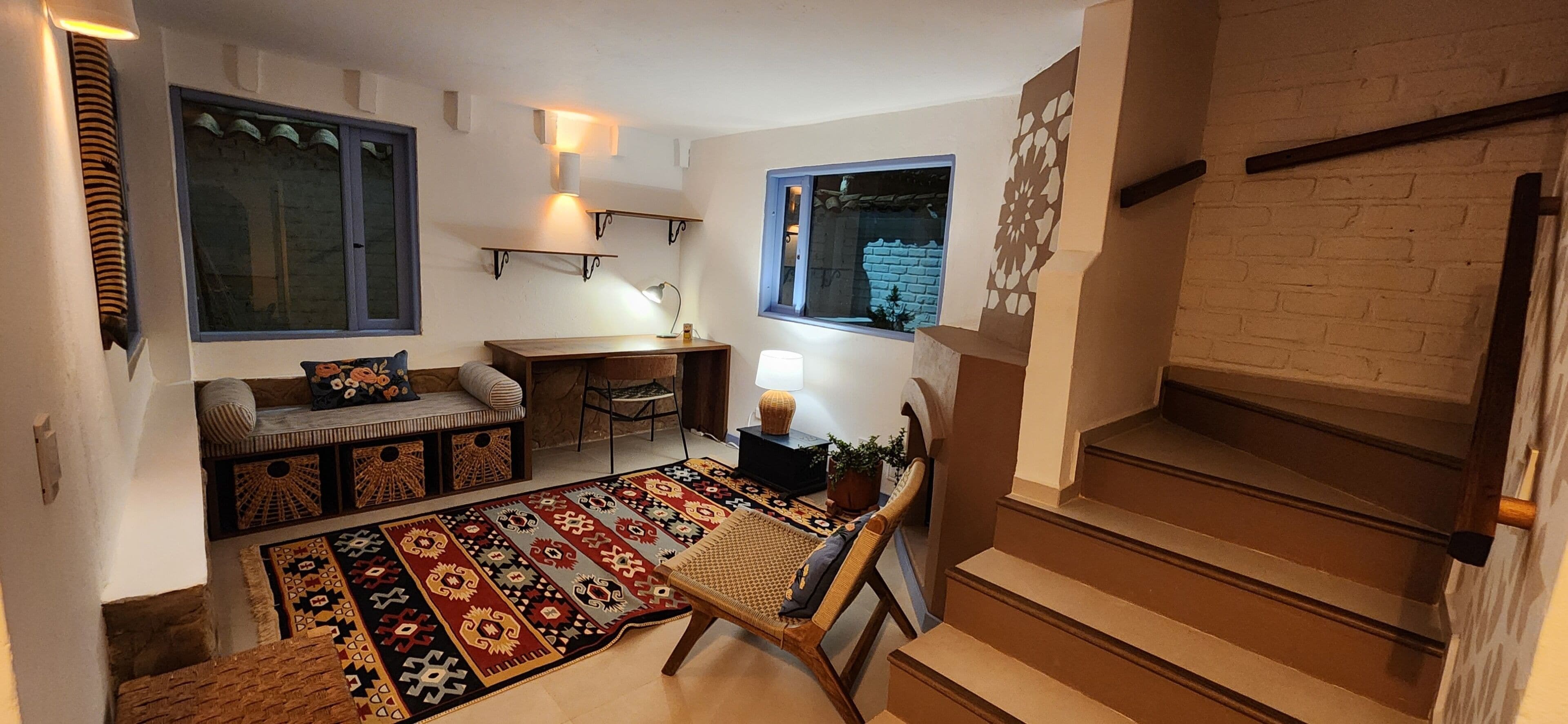 A cozy living area with a sofa, a small table, a lamp, and a patterned rug.