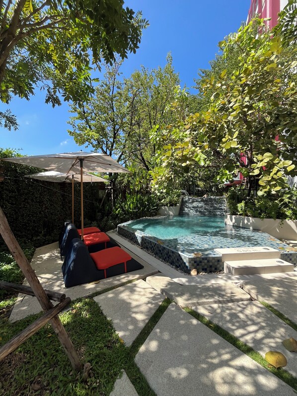 A pool area with a hot tub, lounge chairs, and a pergola. - Monthly, 1 bedroom in cozy The Base condo near Central Phuket (Tambon Wichit)