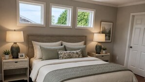 A bedroom with a large bed, two bedside tables, a nightstand, a window, and a door. - Amazing Narragansett house - 5+ bdrm - Brand New!! (Narragansett)