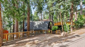 Ein bewaldetes Gebiet mit einer Holzterrasse, einem Steinhaus und einem Schild mit der Adresse 530 W Victoria.