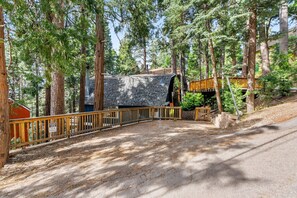 Ein bewaldetes Gebiet mit einer Holzterrasse, einem Steinhaus und einem Schild mit der Adresse 530 W Victoria.