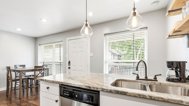A modern kitchen with a dishwasher, a sink, and pendant lights. - Glendale Court Unit 6 (Dallas)