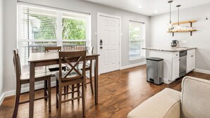 A modern kitchen with white cabinets, a wooden countertop, and a built-in dishwasher. - Glendale Court Unit 6 (Dallas)
