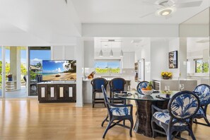A modern kitchen with a dining area, large windows, and a view of the outdoors. - Ocean Views. C202 Vista Waikoloa (Waikoloa Beach Resort)