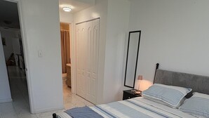 A bedroom with a bed, a bedside table, a mirror, and a wardrobe. - Bed & Breakfast Coconut Grove Miami (Miami)
