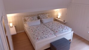 Ein Schlafzimmer mit einem Doppelbett, zwei Nachttischen, einem Beistelltisch und einer Bank.