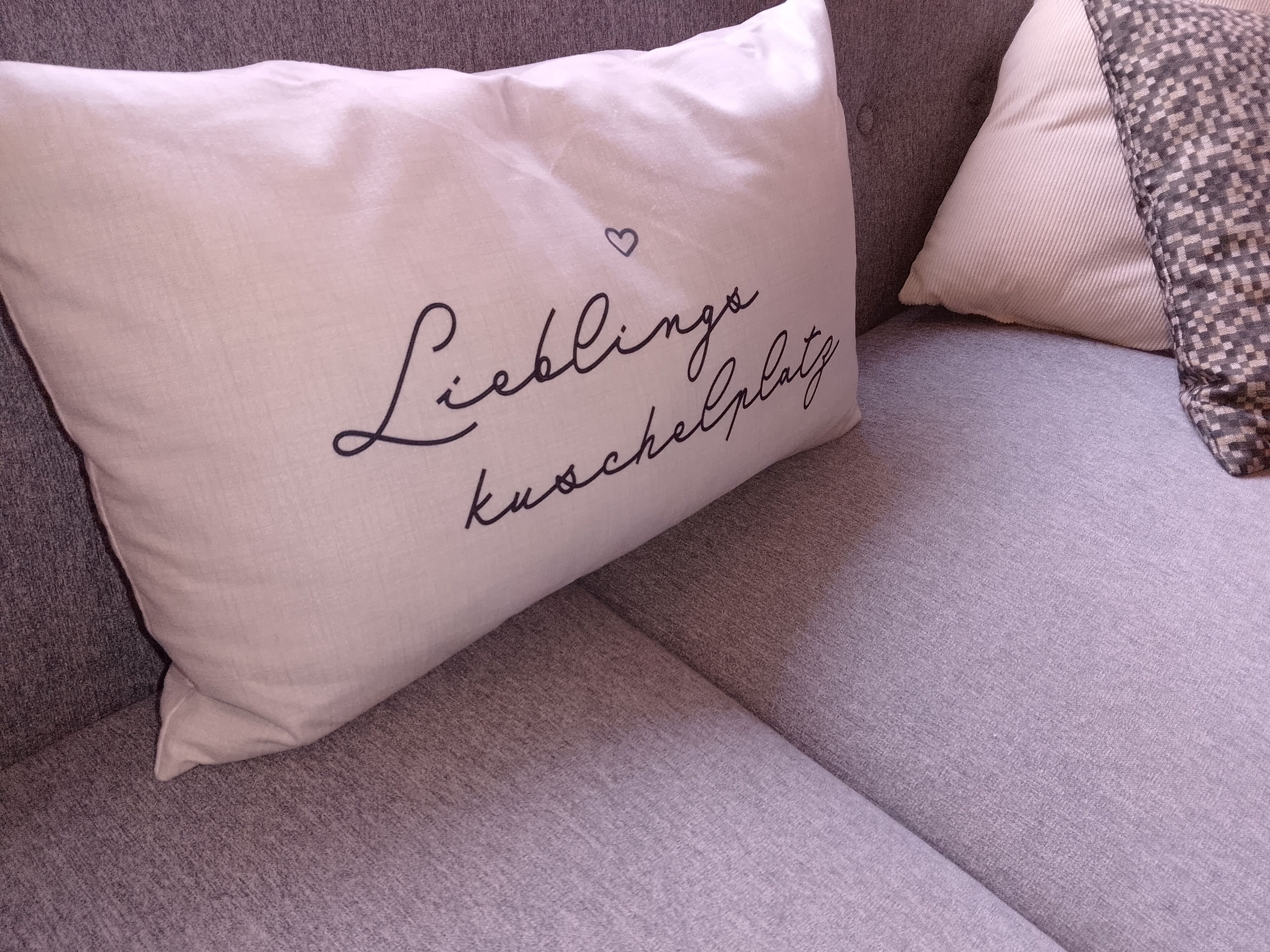 A pillow with text on a sofa.