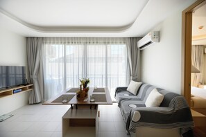 Ein modernes Wohnzimmer mit einer Couch, einem Couchtisch und einem Fernseher.