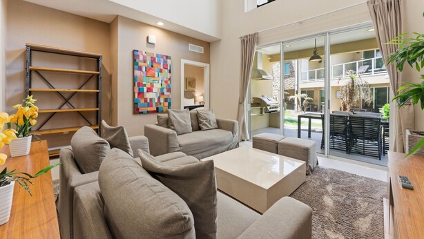 A spacious living area with a sofa set, a coffee table, and a bookshelf. - Designer 4BR Getaway, Sleek Laminate Floors (Four Corners)