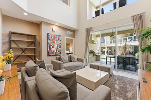 Un vaste espace de vie comprenant un canapé, une table basse et une bibliothèque.