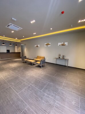 A spacious indoor area with a reception desk, seating arrangements, and artwork on the walls. - Hotel A&M (Alcorcón)