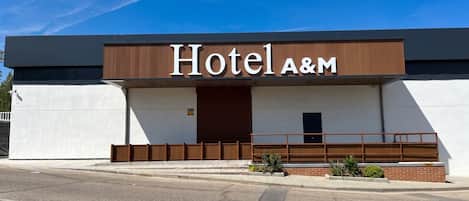 A modern building with a sign that reads 'Hotel A&M.'
