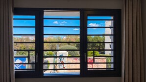 A window with a view of buildings and greenery.