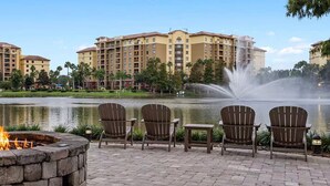 A fire pit with a fire, outdoor seating, a pond, and a fountain. - 2-bedroom deluxe, full kitchen, resort Lake Buena Vista, Disney World - sleeps 6 (Lake Buena Vista)