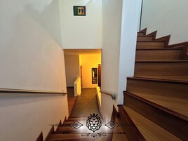 Una escalera de madera con barandillas, que conduce a un espacio interior.