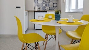 Una cocina moderna con armarios blancos, salpicadero de azulejos azul y blanco, y una ventana con luz natural.