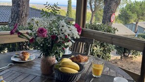 An outdoor breakfast setting with a table, breakfast items, and a view of the landscape.