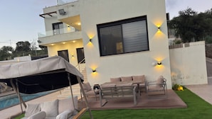 A modern building with a pool, outdoor seating, and a covered area. - Strobia Luxury Chalet 3 Bedrooms 5 Bathrooms with Pool & Jacuzzi & Sunset Views (Allan)