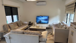 A modern living room with two sofas, a coffee table, and a flat-screen TV. - Strobia Luxury Chalet 3 Bedrooms 5 Bathrooms with Pool & Jacuzzi & Sunset Views (Allan)