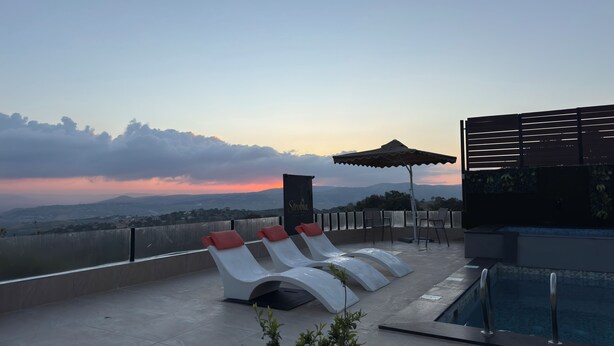 A rooftop pool area with lounge chairs, a pool, and a view of the landscape. - Strobia Luxury Chalet 3 Bedrooms 5 Bathrooms with Pool & Jacuzzi & Sunset Views (Allan)