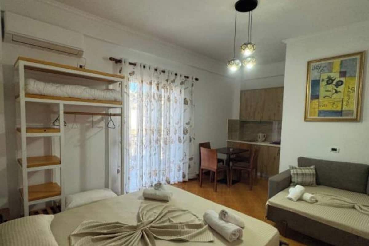 A bedroom with a bed, a wardrobe, a desk, and a sofa.