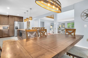 Une cuisine spacieuse avec des meubles en bois, un grand îlot central et des luminaires modernes.