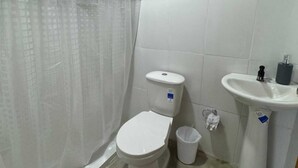 A small bathroom with a toilet, a sink, and a shower curtain. - W cabañas beach, ocean view room 301, two steps from the sea. (Bolívar)